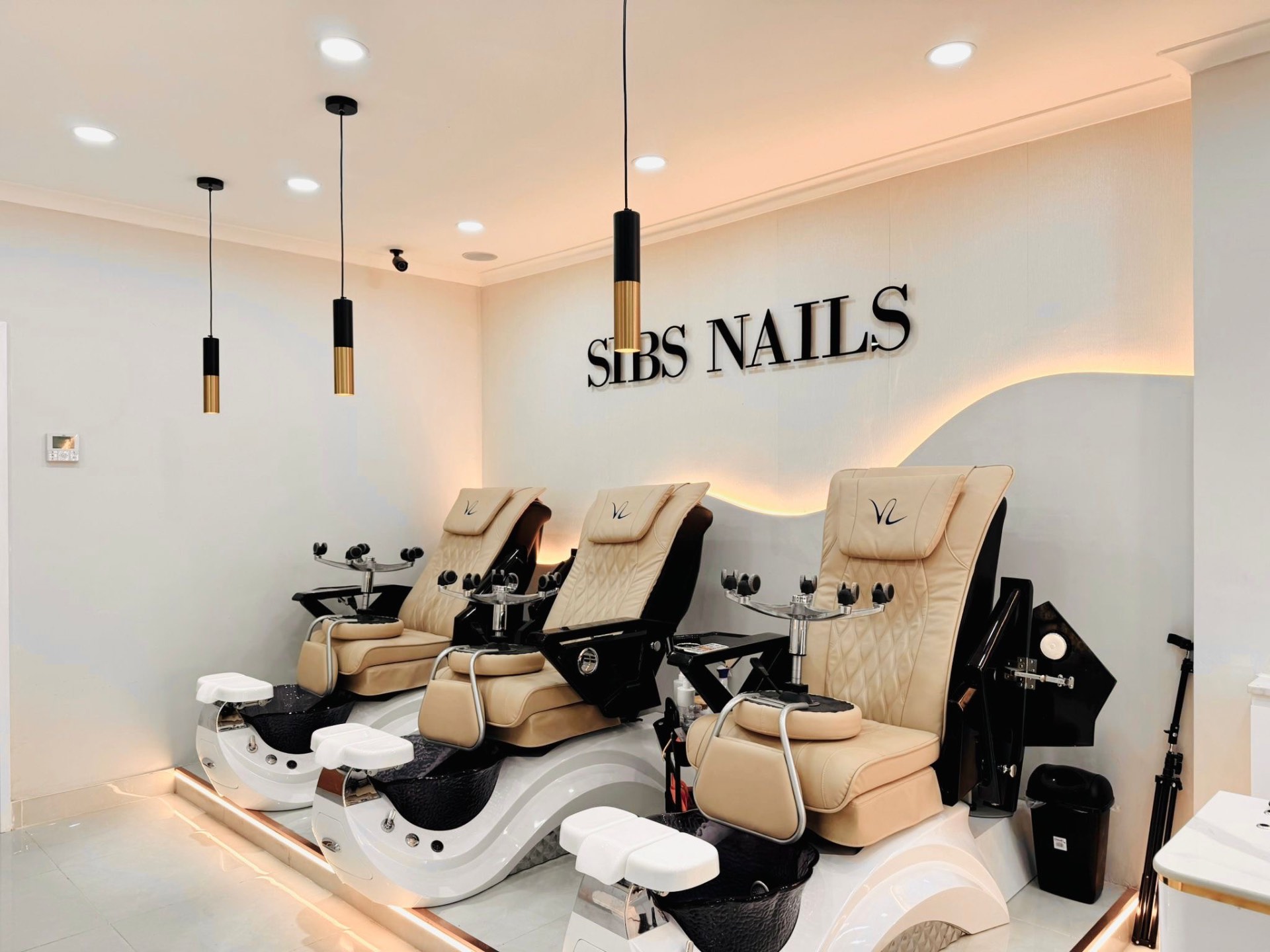 Pedicure chairs beneath the Sibs Nails sign